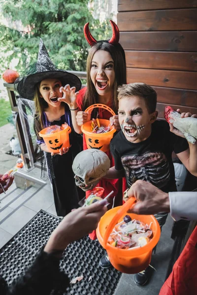 Strašidelné Děti Halloween Kostýmy Vrčení Sousedy Zatímco Drží Kbelíky Sladkostmi — Stock fotografie