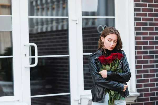Junge Frau Lederjacke Blickt Auf Rote Rosen Auf Einer Städtischen — Stockfoto