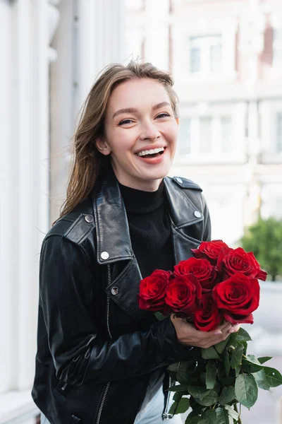 Jovem Mulher Feliz Jaqueta Couro Segurando Rosas Vermelhas Rua Urbana — Fotografia de Stock