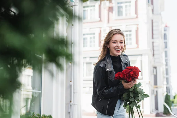 Позитивная Молодая Женщина Кожаной Куртке Красными Розами Городской Улице Европе — стоковое фото