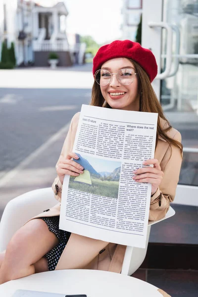 Vrolijke Jonge Vrouw Rode Baret Beige Trench Jas Met Krant — Stockfoto