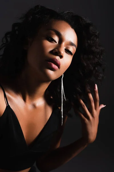 young african american woman in crop top looking at camera isolated on black