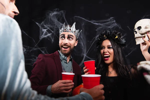 Excited Interracial Friends Halloween Costumes Holding Plastic Cups While Talking — Stock Photo, Image