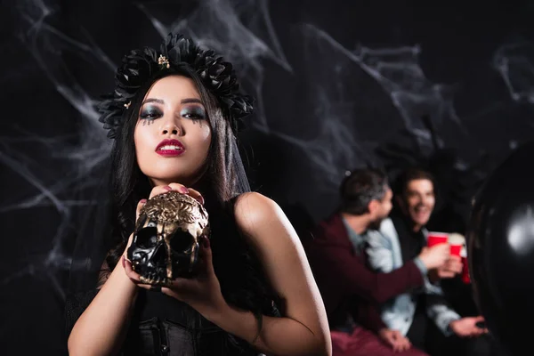 アジアの女性です吸血鬼ハロウィンの衣装ショー怖いです頭蓋骨でカメラで黒 — ストック写真