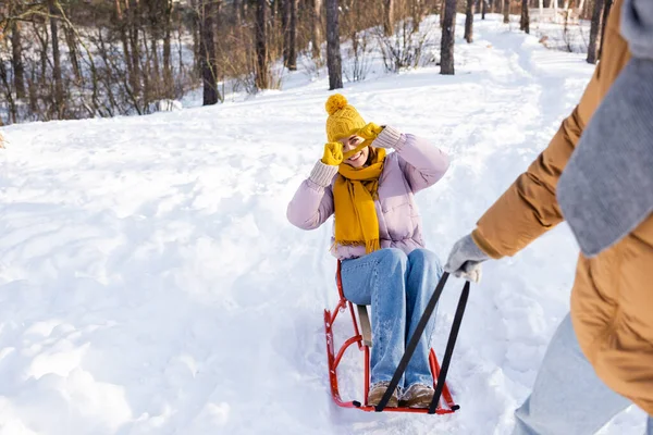 Mujer Sonriente Trineo Mostrando Signo Amor Novio Borroso Parque Invierno — Foto de Stock