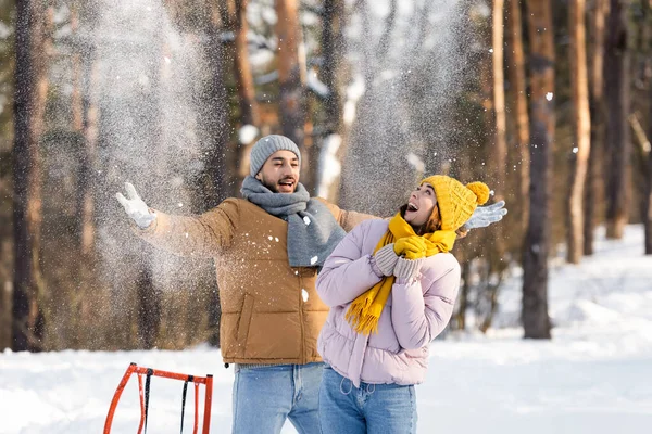 Excited Woman Standing Boyfriend Throwing Snow Sleigh Park — Stock Photo, Image