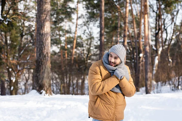 冬の公園に立つ暖かい服の笑顔の男 — ストック写真