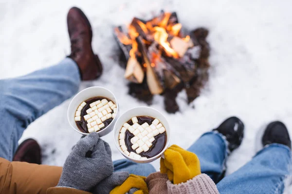 Cropped View Couple Gloves Holding Cups Marshmallows Blurred Bonfire Winter — Stock Photo, Image