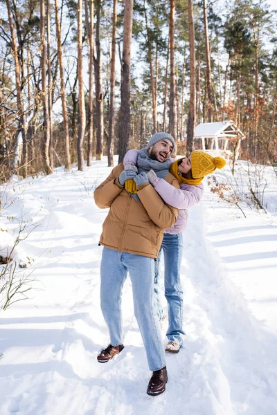 Smiling Woman Embracing Boyfriend Scarf Hat Snowy Park — Stock Photo, Image