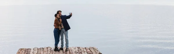 Cheerful Interracial Couple Taking Selfie Pier Sea Banner — Stock Photo, Image