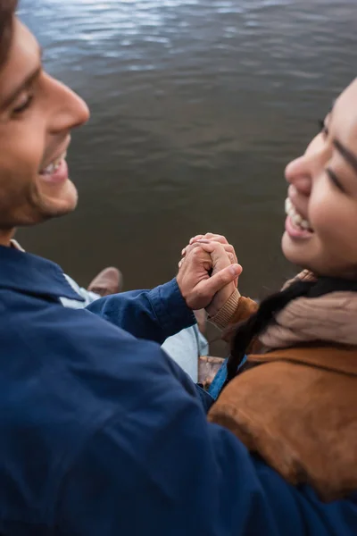 Розмита Міжрасова Пара Тримає Руки Біля Озера — стокове фото