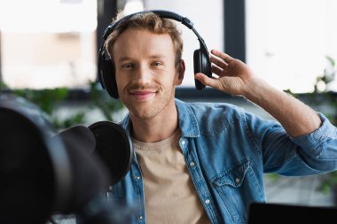 Stüdyoda podcast yaparken kulaklıkları ayarlayan Mutlu Etkili