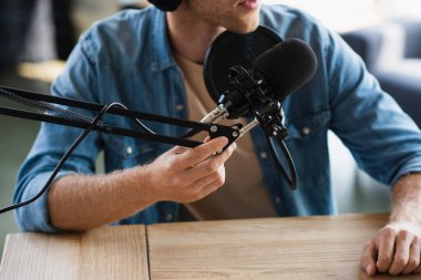 Stüdyoda podcast yaparken mikrofonun yanındaki makas koluna dokunan etkili kişinin görüntüsü kırpıldı 