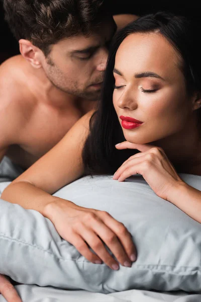 Shirtless Man Kissing Sensual Woman Closed Eyes Bed Isolated Black — Stock Photo, Image