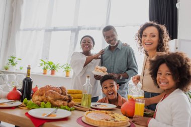 Şükran Günü yemeğinin yanında çocukları olan Afrikalı Amerikalı bir aile. 