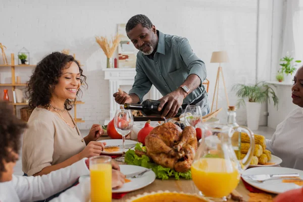 Hombre Afroamericano Sirviendo Vino Cerca Familia Cena Acción Gracias — Foto de Stock