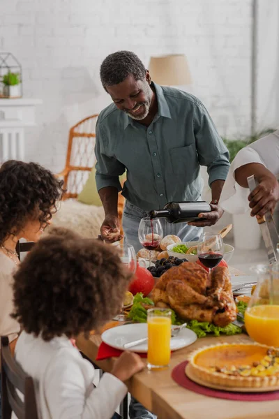 Alegre Afroamericano Abuelo Verter Vino Cerca Familia Cena Acción Gracias — Foto de Stock