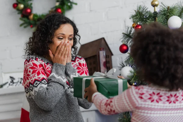 Amazed African American Woman Covering Mouth Hands Blurred Daughter Christmas — Stock Photo, Image