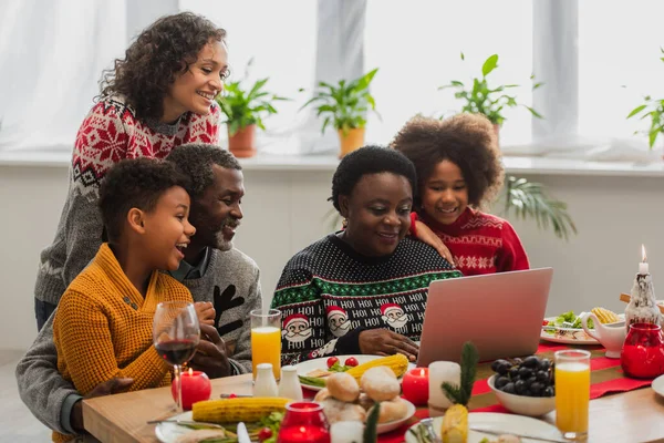 Αφροαμερικανική Οικογένεια Χαμογελώντας Κατά Διάρκεια Βιντεοκλήσης Κοντά Στο Χριστουγεννιάτικο Δείπνο — Φωτογραφία Αρχείου