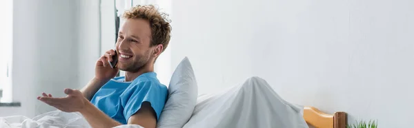 Veselý Muž Mluví Smartphone Zatímco Gestikuluje Nemocnici Banner — Stock fotografie