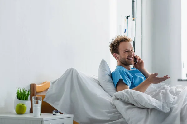 Glad Man Talar Smartphone Medan Gester Sjukhus — Stockfoto