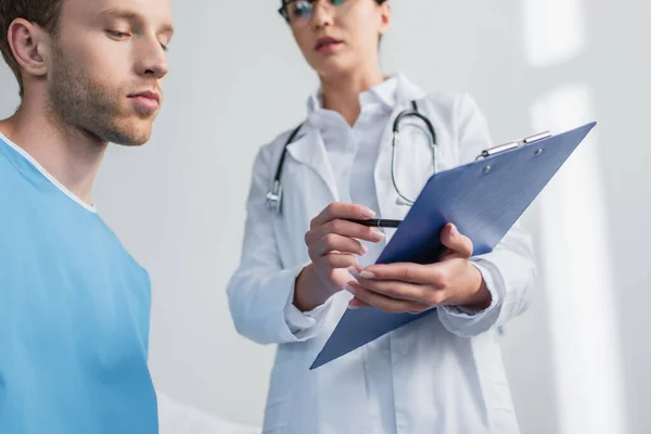 Paciente Mirando Portapapeles Manos Del Médico Clínica —  Fotos de Stock