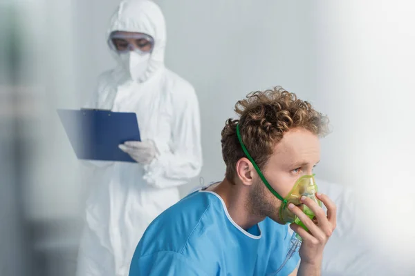 Sick Patient Breathing Oxygen Mask Blurred Doctor Hazmat Suit Holding — Stock Photo, Image