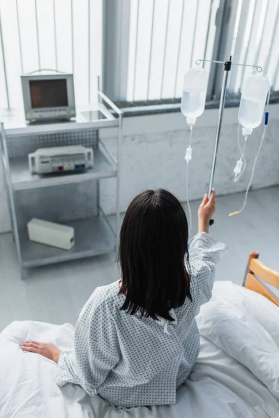 Задний Вид Пациента Сидящего Больничной Койке Держащегося Руку Счетчике Капель — стоковое фото