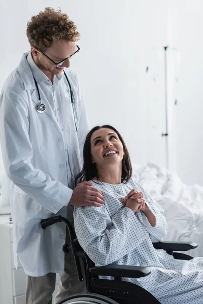 Medico Riccio Camice Bianco Piedi Dietro Sorridente Donna Disabile Sedia — Foto Stock