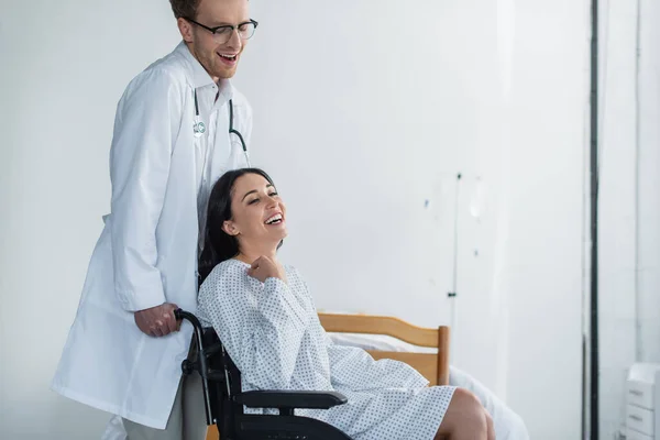 Curly Doctor White Coat Standing Joyful Disabled Woman Wheelchair — Stock Photo, Image