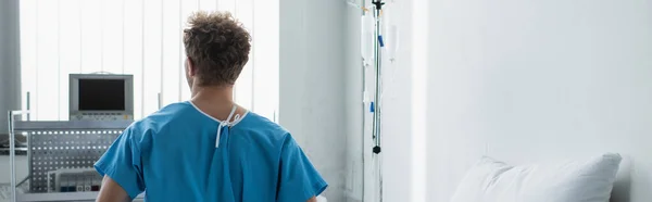 Visão Traseira Homem Encaracolado Vestido Paciente Sentado Hospital Banner — Fotografia de Stock