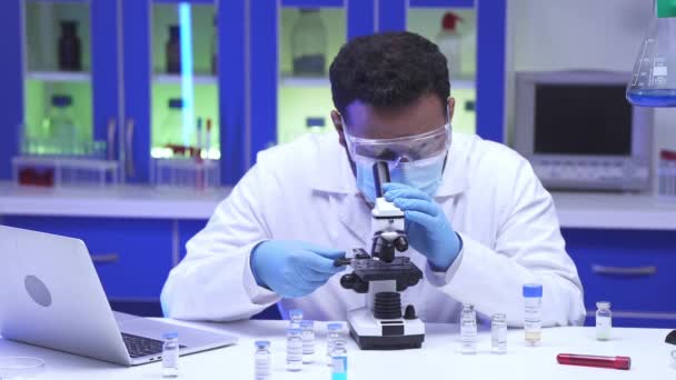 Indisk Forsker Briller Med Mikroskop Nær Vaksiner Laptop Laboratorium – stockvideo