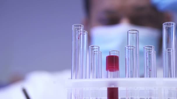 Reagenzgläser Und Blutprobe Bei Verschwommenem Wissenschaftler Labor — Stockvideo