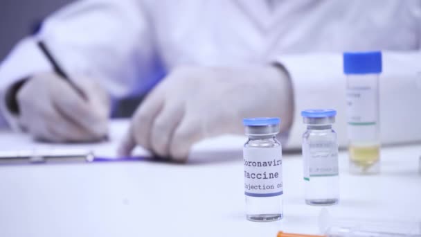 科学家在实验室剪贴板上写下的科罗纳韦疫苗的剪贴图 — 图库视频影像