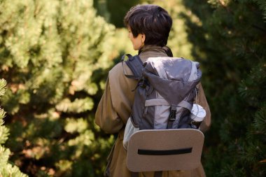 Aktif kıdemli kadın ağaçlarla çevrili kayalık patikalarda yürürken doğayı keşfediyor..