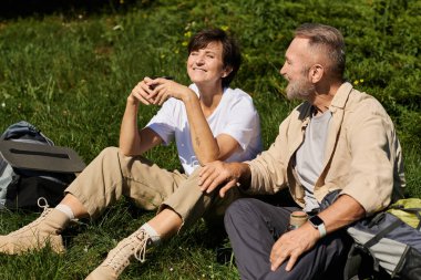 Üst düzey bir çift dağda yürüyüş yaparken birlikte rahatlıyor, gülümsüyor ve doğanın tadını çıkarıyor..