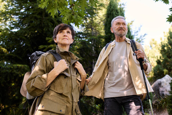 Active seniors hike together, enjoying nature and mountains during a sunny day outdoors.