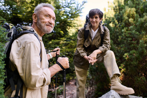Active seniors explore nature as they hike a scenic mountain trail, sharing joyful moments.