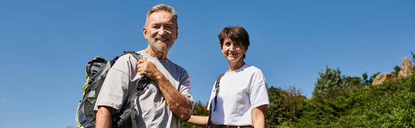 Активные пожилые люди прогуливаются вместе, изучая природу и наслаждаясь свежим горным воздухом на пенсии, баннер