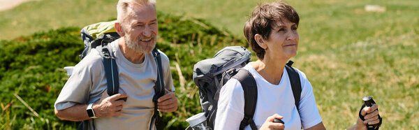 Старшая пара прогулок в горах, наслаждаясь свежим воздухом и потрясающим видом, баннер