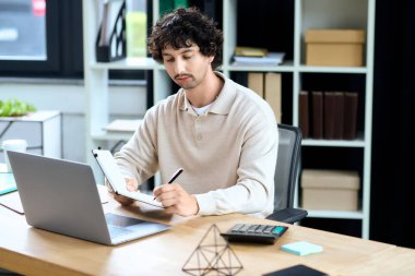 Young man captures his ideas on a notepad, immersed in tasks at his sleek office workspace.
