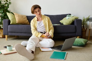 Havalı genç adam sıcak bir oturma odasında kahvenin tadını çıkarırken not alıyor..