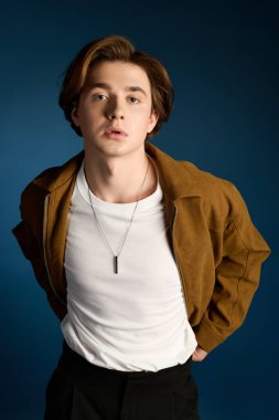 Yakışıklı genç adam moda ve çarpıcı bir ortamda çekici bir ifade sergiliyor..