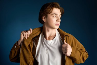 Şık bir genç adam havalı ceketini ve kendine güvenini sergiliyor..