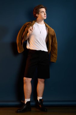 Modaya uygun genç adam rahat bir pozla modaya uygun kıyafetini sergiliyor..