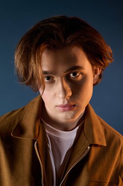 Yakışıklı genç bir adam kendine güvenen bir ifade ve canlı bir zemin ile modaya uygun tarzını sergiliyor..