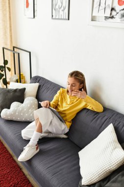 Yeni nesil alfa kız kanepede dinleniyor, sıcak bir evde tabletle meşgul oluyor..