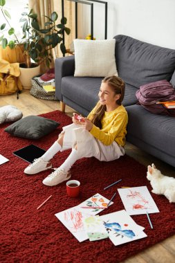 Gen alfa kızı rahat bir şekilde oturma odasında otururken renkli sanat eserleri yapmaktan zevk alır..