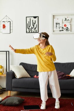 Sanal gerçekliğe dalmış, rahat ev ortamında eğlenen günlük kıyafetli genç bir kız..