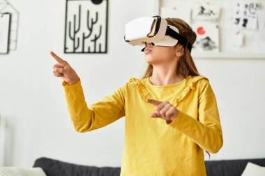 Sarı elbiseli bir kız, oturma odasında sanal maceralar keşfediyor..